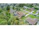 Aerial view showcasing a home with a screened-in pool and a scenic pond in a lush neighborhood at 18 Foxfords, Ormond Beach, FL 32174