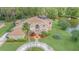 Aerial view of a house with solar panels, a circular driveway, and lush landscaping at 18 Foxfords, Ormond Beach, FL 32174