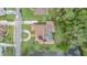 Aerial view from above showcases a home featuring a screened-in pool, solar panels, and a circle driveway at 18 Foxfords, Ormond Beach, FL 32174