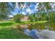 Pond view from the backyard of home surrounded by lush trees and landscaping at 18 Foxfords, Ormond Beach, FL 32174