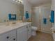 Bathroom featuring a white vanity, mirror, decorative seashells, and a glass-enclosed shower at 18 Foxfords, Ormond Beach, FL 32174