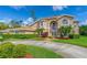 Beautiful two-story home with a well-manicured lawn, mature trees, and a circular driveway providing a welcoming curb appeal at 18 Foxfords, Ormond Beach, FL 32174