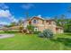Two-story home with manicured lawn, palm trees, and well-maintained landscaping at 18 Foxfords, Ormond Beach, FL 32174