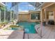 Enclosed pool and hot tub with rock features, surrounded by tiled patio and natural light at 18 Foxfords, Ormond Beach, FL 32174