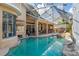 Screened indoor pool and patio area with bar, seating, and rock waterfall feature at 18 Foxfords, Ormond Beach, FL 32174