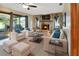 Cozy living room featuring stone fireplace, plush seating, and sliding glass doors to the backyard at 1904 Viking Ave, Deltona, FL 32725