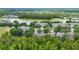 Overhead view of a community featuring lush trees, a serene lake, and well-maintained residences, showcasing a tranquil environment at 191 Sedona Cir, Daytona Beach, FL 32124