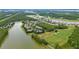 Overhead view featuring a community near a green golf course and a shimmering lake at 191 Sedona Cir, Daytona Beach, FL 32124