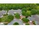 Aerial view of the property showcasing lush landscaping, a circular driveway, and proximity to wooded areas at 191 Sedona Cir, Daytona Beach, FL 32124