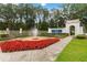 Elegant entrance to LPGA International featuring a water fountain and vibrant red flowers at 191 Sedona Cir, Daytona Beach, FL 32124