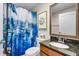 Nautical themed bathroom with decorative shower curtain, dark countertop and decorative painting of a ship's wheel at 19343 Moorgate St, Orlando, FL 32833