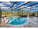 Screened pool with stone decking and a rock waterfall feature at 19343 Moorgate St, Orlando, FL 32833