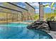 Stunning screened pool area with a captivating rock waterfall feature, enhanced by beautiful landscaping and an open view at 19343 Moorgate St, Orlando, FL 32833