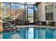Enclosed pool area featuring a charming rock waterfall, lush greenery, and stylish seating for a relaxing retreat at 19343 Moorgate St, Orlando, FL 32833