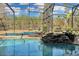 Screened-in pool with a rock waterfall feature, built-in seating, and mature trees in the back yard at 19343 Moorgate St, Orlando, FL 32833