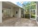 A screened lanai has a ceiling fan, outdoor wall decor and mature landscaping at 200 Gala Cir, Daytona Beach, FL 32124
