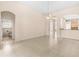 Open-concept living room with tile flooring, arched doorways, and kitchen access at 200 Gala Cir, Daytona Beach, FL 32124