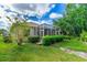 Enclosed screen patio surrounded by lush landscaping on a manicured lawn, perfect for outdoor living at 200 Gala Cir, Daytona Beach, FL 32124