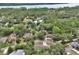 Expansive aerial perspective of homes surrounded by dense, verdant forests and a lake at 2004 Quail Hollow Dr, Deland, FL 32720