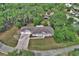 Birds-eye view of a grey home with a three-car garage, stone driveway, and front lawn at 2004 Quail Hollow Dr, Deland, FL 32720