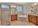 Bright bathroom featuring double vanities, a large soaking tub with decorative tile, and a glass-enclosed shower at 2004 Quail Hollow Dr, Deland, FL 32720