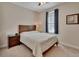 Cozy bedroom featuring a large window, neutral walls, and a comfortable bed with striped bedding at 2004 Quail Hollow Dr, Deland, FL 32720