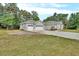 Three car attached garage with driveway and manicured lawn at 2004 Quail Hollow Dr, Deland, FL 32720
