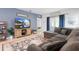 Comfortable living area with a gray sectional sofa, patterned rug, entertainment center with a TV and a view to the hall at 211 Duke Dr, Deland, FL 32724