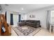 Bright living room with large gray couch, decorative rug, and sliding glass doors for access to the backyard at 211 Duke Dr, Deland, FL 32724