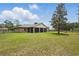 Wide shot of the home's spacious, fully-fenced backyard with lush green grass and shade trees at 226 Treeline Ln, Ormond Beach, FL 32174