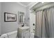 Bathroom features a tub with gray shower curtain, updated fixtures, and modern vanity sink at 226 Treeline Ln, Ormond Beach, FL 32174