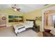Bright bedroom with ceiling fan, decorative wave art, and yellow walls at 226 Treeline Ln, Ormond Beach, FL 32174