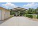 View of the open carport next to detached garage with a boat and motorcycle parked on the driveway at 226 Treeline Ln, Ormond Beach, FL 32174