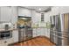 A kitchen featuring stainless steel appliances, white cabinets, granite countertops, and hardwood floors at 226 Treeline Ln, Ormond Beach, FL 32174