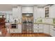 A kitchen featuring stainless steel appliances, white cabinets, granite countertops, and hardwood floors at 226 Treeline Ln, Ormond Beach, FL 32174