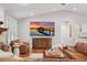 Well-lit living room with a large TV, wooden floors, and cozy seating arrangement at 226 Treeline Ln, Ormond Beach, FL 32174