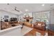Spacious living room with a cozy brick fireplace, wood floors, and leather sectional sofa at 226 Treeline Ln, Ormond Beach, FL 32174