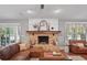 Warm living room featuring a brick fireplace, hardwood floors, and a comfortable leather sofa at 226 Treeline Ln, Ormond Beach, FL 32174