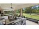 Screened patio showcasing a dining table and chairs, overlooking a spacious, green lawn with a wooded perimeter at 226 Treeline Ln, Ormond Beach, FL 32174