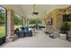 Enclosed brick patio with a full outdoor living area with mounted tv and view of fenced in backyard at 226 Treeline Ln, Ormond Beach, FL 32174