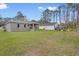 A lush green backyard featuring a covered patio, green grass and a detached garage at 2379 8Th Ave, Deland, FL 32724