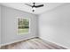 Sunlit bedroom with large window and light gray wood-look floors at 2379 8Th Ave, Deland, FL 32724