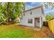 A fenced backyard features green grass, a small patio and a view of the back of the house at 2418 Formosa Ave, Orlando, FL 32804