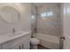 Bathroom with modern bathtub and shower combination, round mirror, and white cabinets at 248 S Virginia Ave, Deland, FL 32724