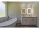 Modern bathroom featuring double vanities, a freestanding tub, and elegant lighting at 248 S Virginia Ave, Deland, FL 32724