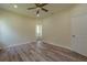 Spacious bedroom featuring a ceiling fan, wood floors, and an ensuite bathroom at 248 S Virginia Ave, Deland, FL 32724