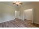 Bedroom with hardwood flooring, ceiling fan, and an open closet with shelving at 248 S Virginia Ave, Deland, FL 32724
