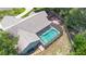 Aerial view of a home with a screened-in pool, fenced-in area, lush landscaping, and a well-maintained roof at 25 Pine Glen Dr, Debary, FL 32713