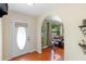 Inviting entryway with an arched doorway, leading to a living area with hardwood floors and a comfortable leather sofa at 25 Pine Glen Dr, Debary, FL 32713