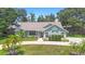 Charming single-story home with a well-manicured lawn, mature trees, and a circular driveway at 25 Pine Glen Dr, Debary, FL 32713